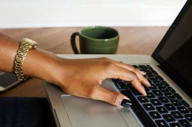 A woman's hand on a laptop